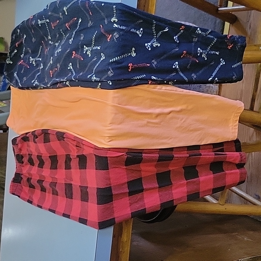 Three pair of women's leggings size XL. Colores are orange blue red and black.
